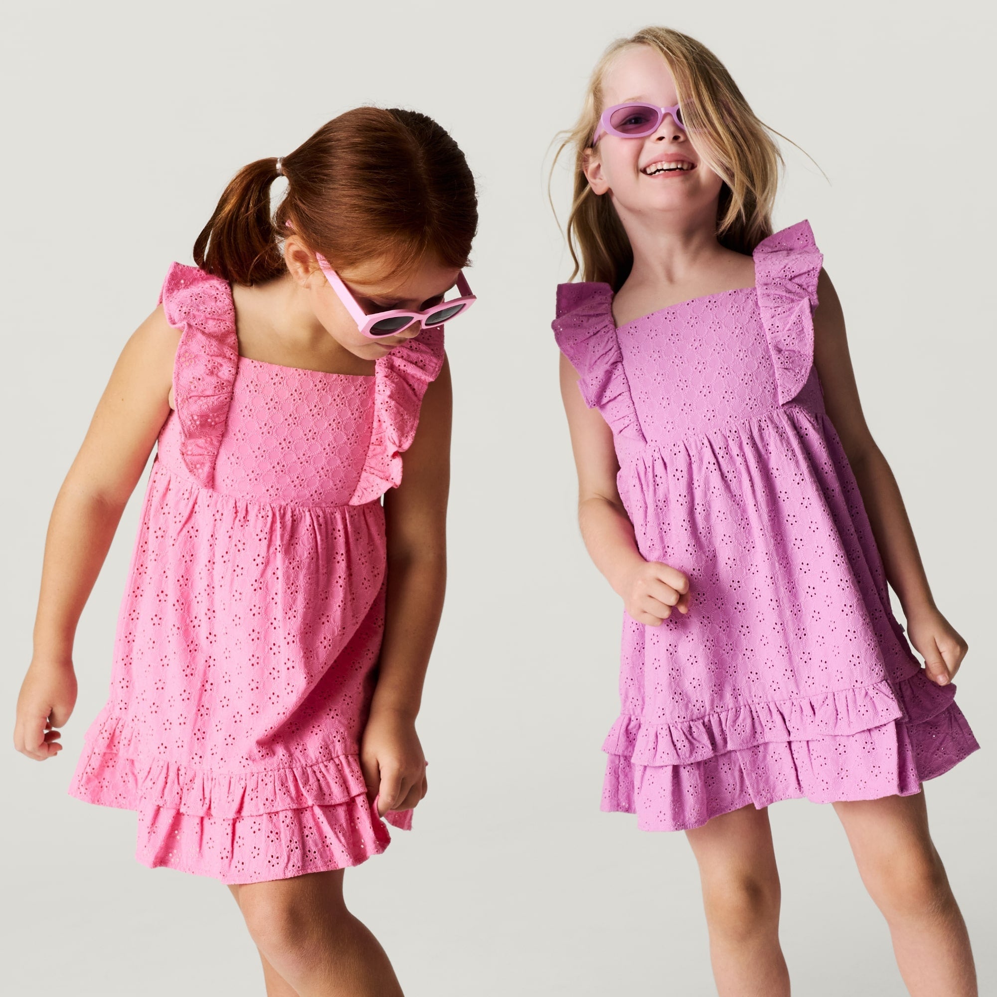 two young girls wearing pink and lavender colored dresses